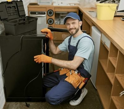 joyful-young-man-fixing-fridge-in-kitchen.jpg